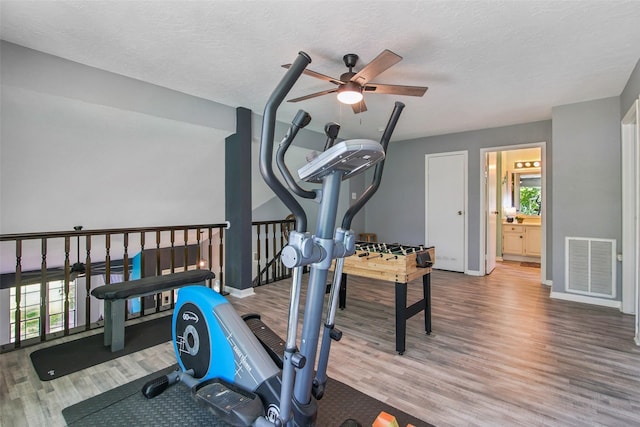 5210 Creek Shadows Dr, Houston, TX 77339 - workout area featuring ceiling fan, wood finished floors, and a textured ceiling