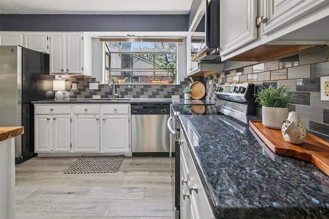 5210 Creek Shadows Dr, Houston, TX 77339 - kitchen with appliances with stainless steel finishes, white cabinets, dark stone countertops, and tasteful backsplash