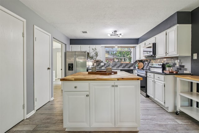 5210 Creek Shadows Dr, Houston, TX 77339 - kitchen with stainless steel appliances, wood counters, white cabinetry, decorative backsplash, and light wood finished floors