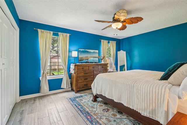 5210 Creek Shadows Dr, Houston, TX 77339 - bedroom featuring wood finished floors, a textured ceiling, ceiling fan, and a closet