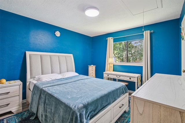5210 Creek Shadows Dr, Houston, TX 77339 - bedroom featuring attic access, a textured ceiling, and wood finished floors