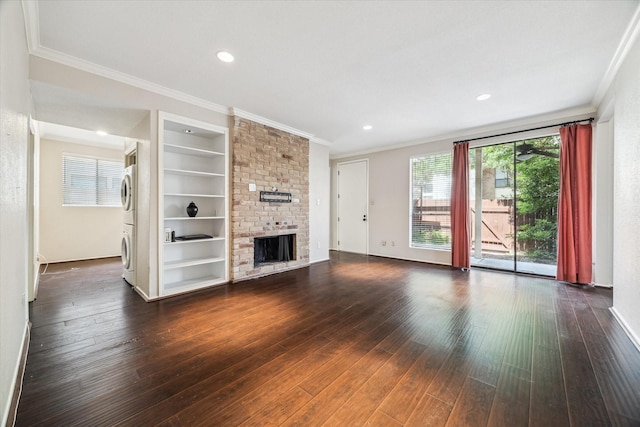 1881 Bering Dr Unit 83, Houston, TX 77057 - unfurnished living room featuring estacked washer and dryer, ornamental molding, a fireplace, dark wood-type flooring, and built in shelves