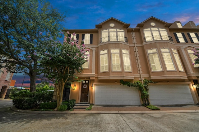 2930 Brompton Square Dr, Houston, TX 77025 - townhome / multi-family property with a balcony, an attached garage, stucco siding, and driveway