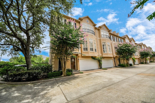 2930 Brompton Square Dr, Houston, TX 77025 - multi unit property featuring a garage, stucco siding, driveway, and a balcony