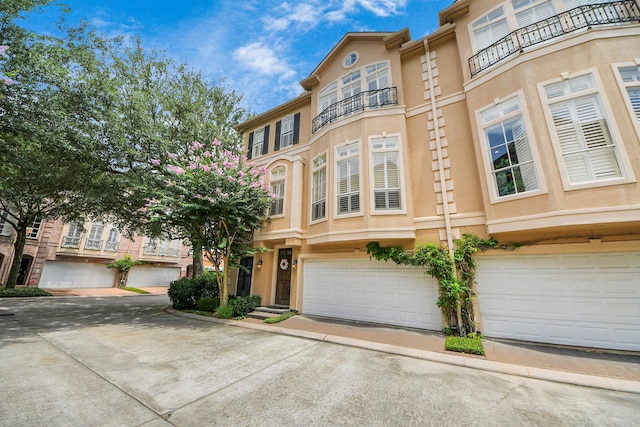 2930 Brompton Square Dr, Houston, TX 77025 - view of front facade with stucco siding, a garage, and a balcony