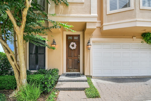 2930 Brompton Square Dr, Houston, TX 77025 - view of exterior entry featuring stucco siding, an attached garage, and driveway