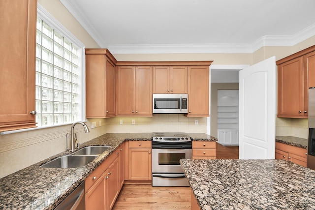 2930 Brompton Square Dr, Houston, TX 77025 - kitchen with stainless steel appliances, plenty of natural light, dark stone countertops, tasteful backsplash, and ornamental molding