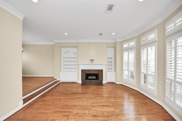 2930 Brompton Square Dr, Houston, TX 77025 - unfurnished living room with healthy amount of natural light, light wood-style floors, ornamental molding, a fireplace with flush hearth, and recessed lighting