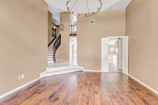 12102 Moorcreek Dr, Houston, TX 77070 - unfurnished living room featuring a chandelier, a towering ceiling, wood finished floors, and stairway