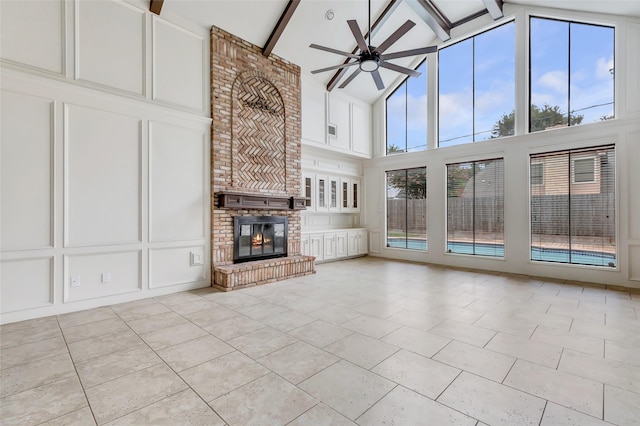 12102 Moorcreek Dr, Houston, TX 77070 - unfurnished living room featuring ceiling fan, high vaulted ceiling, a decorative wall, a brick fireplace, and light tile patterned floors