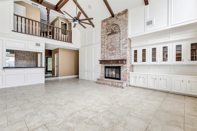 12102 Moorcreek Dr, Houston, TX 77070 - unfurnished living room with a decorative wall, high vaulted ceiling, a brick fireplace, a ceiling fan, and beamed ceiling