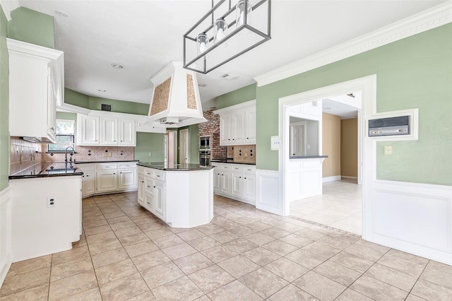 12102 Moorcreek Dr, Houston, TX 77070 - kitchen with dark countertops, light tile patterned floors, wainscoting, decorative backsplash, and ornamental molding