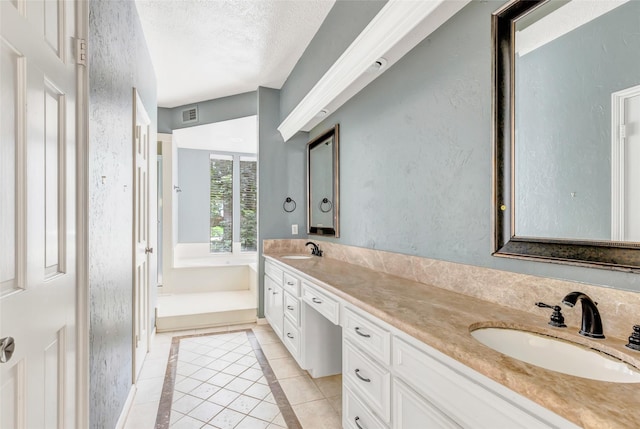 12102 Moorcreek Dr, Houston, TX 77070 - bathroom featuring double vanity, tile patterned floors, inlaid floor details, and a textured ceiling