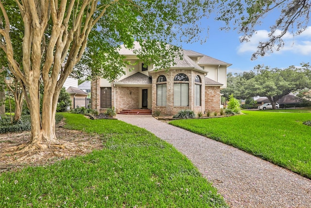 12102 Moorcreek Dr, Houston, TX 77070 - view of front facade with brick siding, a front yard, and a shingled roof