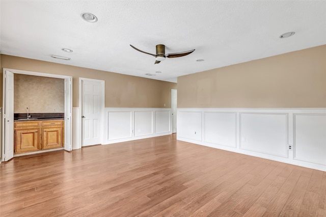 12102 Moorcreek Dr, Houston, TX 77070 - empty room featuring a ceiling fan, a decorative wall, light wood-style floors, a wainscoted wall, and recessed lighting