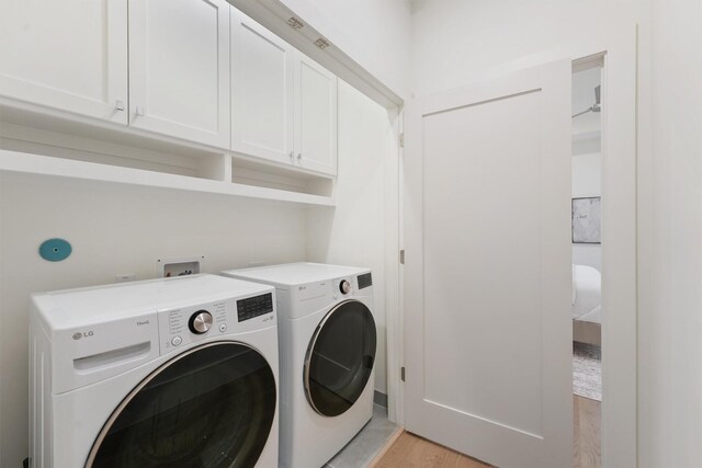 5405 Dickson St, Houston, TX 77007 - laundry area with cabinet space, independent washer and dryer, and light wood-style flooring