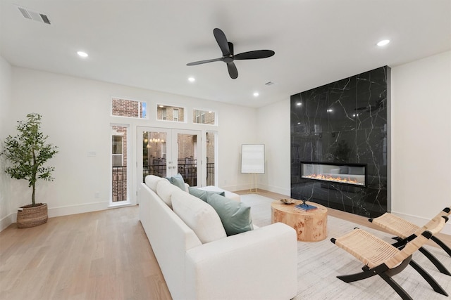 5405 Dickson St, Houston, TX 77007 - living room with french doors, light wood-style flooring, recessed lighting, a premium fireplace, and a ceiling fan