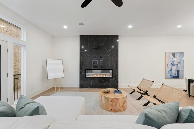 5405 Dickson St, Houston, TX 77007 - living room featuring wood finished floors, a high end fireplace, a ceiling fan, and recessed lighting