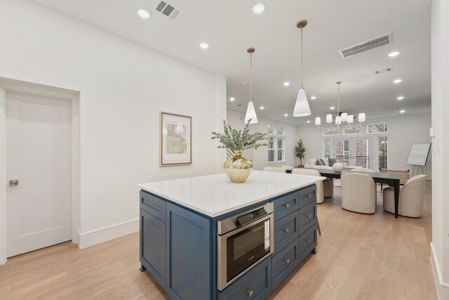 5405 Dickson St, Houston, TX 77007 - kitchen with light wood finished floors, stainless steel microwave, a kitchen island, light countertops, and recessed lighting