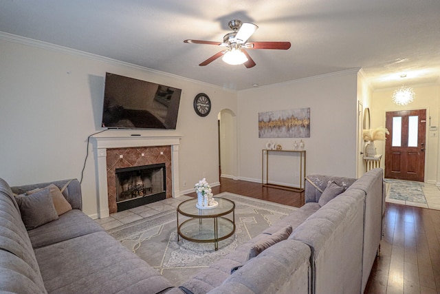 17803 Inland Oaks Dr, Richmond, TX 77407 - living area with arched walkways, hardwood / wood-style flooring, ceiling fan, crown molding, and a premium fireplace
