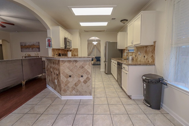 17803 Inland Oaks Dr, Richmond, TX 77407 - kitchen featuring stainless steel appliances, light tile patterned floors, white cabinets, and decorative backsplash