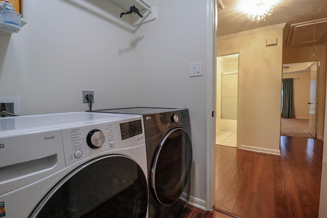 17803 Inland Oaks Dr, Richmond, TX 77407 - laundry room featuring independent washer and dryer, wood finished floors, ornamental molding, and attic access