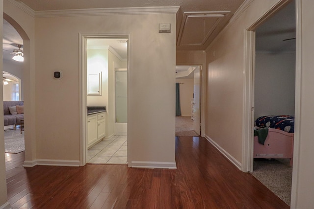 17803 Inland Oaks Dr, Richmond, TX 77407 - hallway with arched walkways, hardwood / wood-style floors, attic access, and crown molding