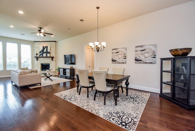 19750 Lago Terrace Loop, Richmond, TX 77407 - dining space with ceiling fan, dark wood finished floors, a stone fireplace, a chandelier, and recessed lighting