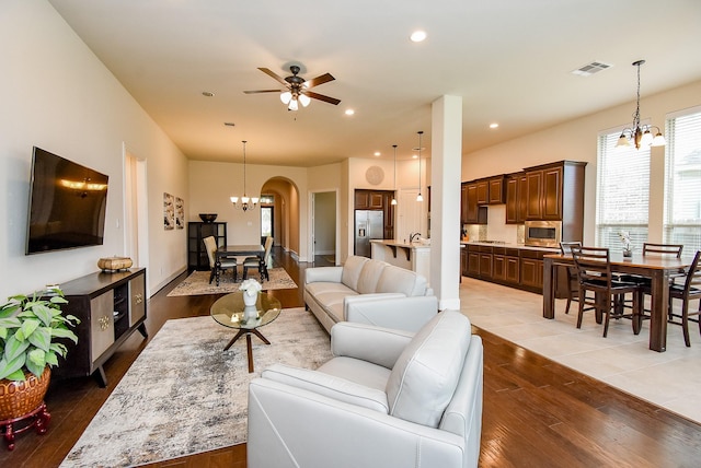19750 Lago Terrace Loop, Richmond, TX 77407 - living room featuring a chandelier, light wood-type flooring, a ceiling fan, arched walkways, and recessed lighting