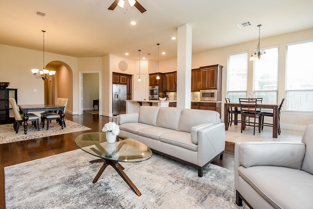 19750 Lago Terrace Loop, Richmond, TX 77407 - living area featuring arched walkways, dark wood-type flooring, ceiling fan, a chandelier, and recessed lighting
