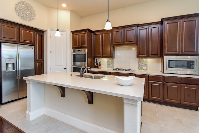 19750 Lago Terrace Loop, Richmond, TX 77407 - kitchen featuring appliances with stainless steel finishes, a breakfast bar, hanging light fixtures, and light countertops