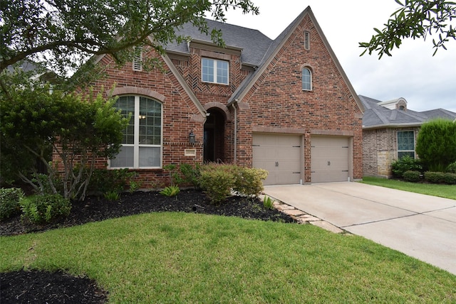 19750 Lago Terrace Loop, Richmond, TX 77407 - english style home with brick siding, driveway, a front lawn, and an attached garage