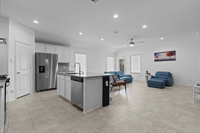 14205 Dream Rd, New Caney, TX 77357 - kitchen featuring appliances with stainless steel finishes, stone counters, open floor plan, a ceiling fan, and white cabinets