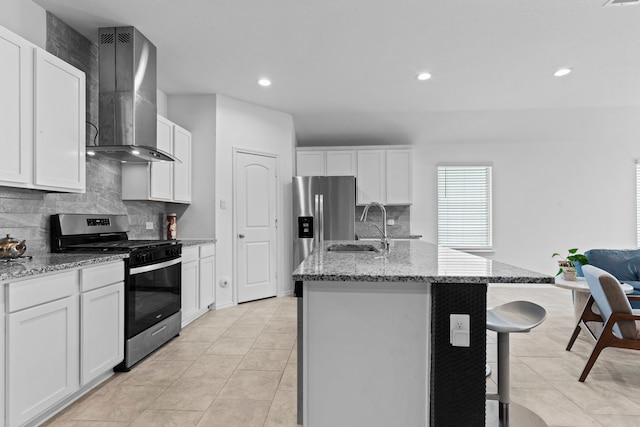 14205 Dream Rd, New Caney, TX 77357 - kitchen featuring stainless steel appliances, wall chimney exhaust hood, decorative backsplash, light stone countertops, and recessed lighting
