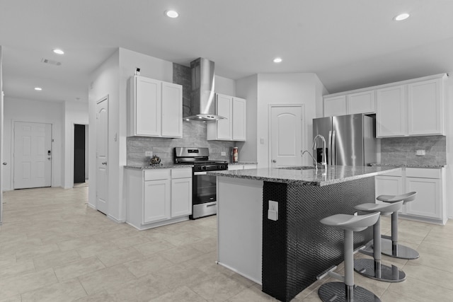 14205 Dream Rd, New Caney, TX 77357 - kitchen with stainless steel appliances, wall chimney exhaust hood, decorative backsplash, light stone countertops, and a breakfast bar area