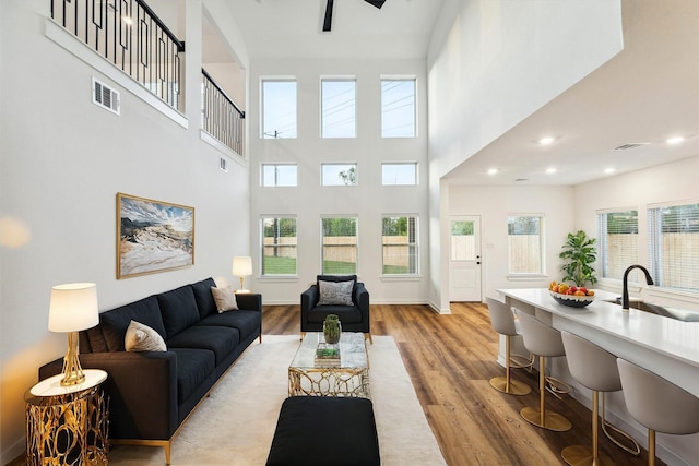 390 Kendall Crest Dr, Alvin, TX 77511 - living room featuring light wood-style flooring, a high ceiling, and recessed lighting