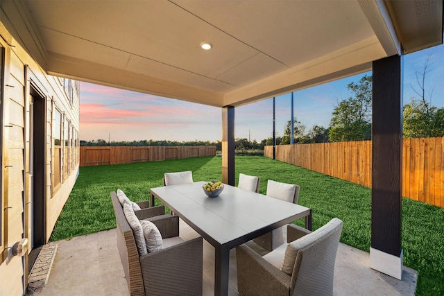 390 Kendall Crest Dr, Alvin, TX 77511 - patio terrace at dusk with a patio, outdoor dining area, and a fenced backyard