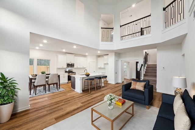 390 Kendall Crest Dr, Alvin, TX 77511 - living room with stairs, light wood finished floors, healthy amount of natural light, recessed lighting, and a towering ceiling