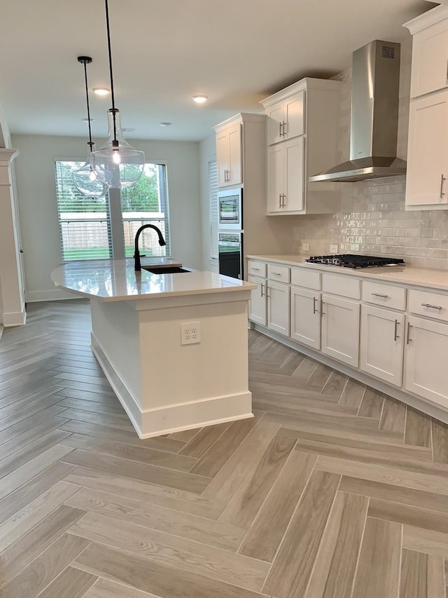 12515 Tullich Run Dr, Humble, TX 77346 - kitchen featuring wall chimney exhaust hood, stainless steel appliances, light countertops, white cabinets, and backsplash