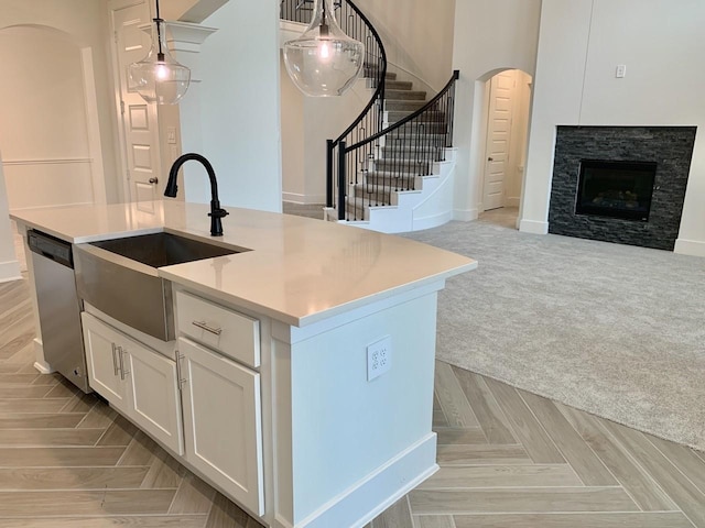 12515 Tullich Run Dr, Humble, TX 77346 - kitchen featuring open floor plan, dishwasher, arched walkways, white cabinetry, and pendant lighting