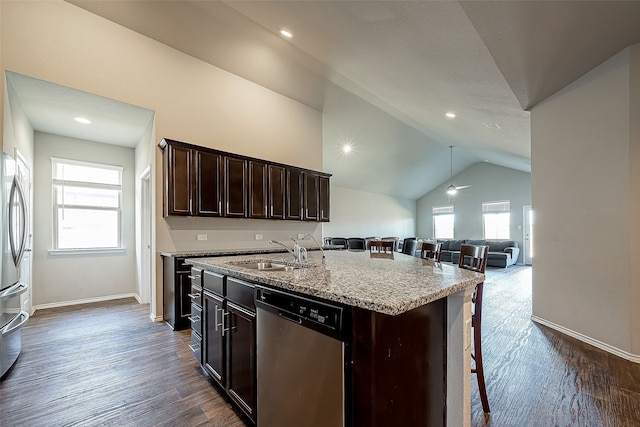 18623 Swainboro Dr, New Caney, TX 77357 - kitchen featuring stainless steel appliances, lofted ceiling, dark brown cabinets, dark wood finished floors, and a kitchen island with sink