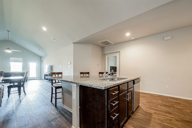 18623 Swainboro Dr, New Caney, TX 77357 - kitchen with a breakfast bar, wood finished floors, an island with sink, dark brown cabinets, and open floor plan
