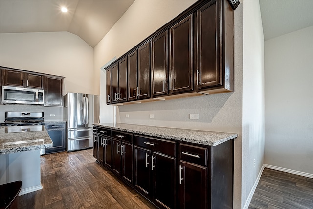 18623 Swainboro Dr, New Caney, TX 77357 - kitchen with appliances with stainless steel finishes, lofted ceiling, dark wood finished floors, dark brown cabinets, and light stone counters