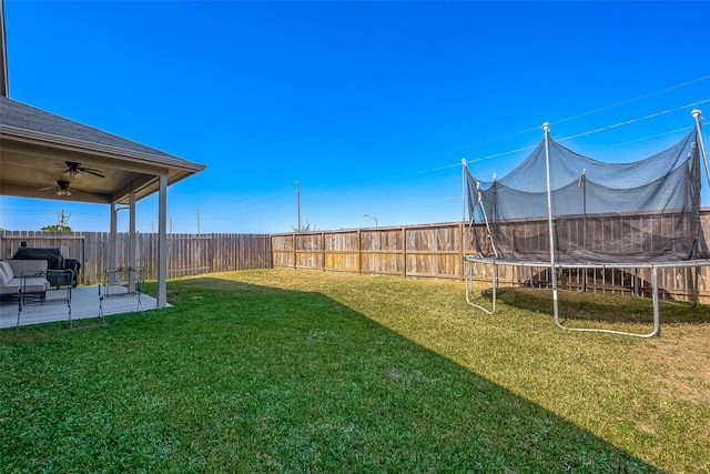 18623 Swainboro Dr, New Caney, TX 77357 - fenced backyard featuring a trampoline, a ceiling fan, and a patio area