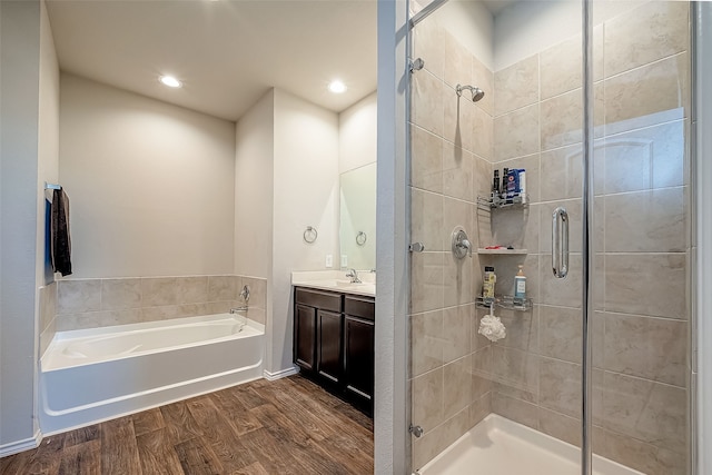 18623 Swainboro Dr, New Caney, TX 77357 - bathroom with wood finished floors, a stall shower, a garden tub, vanity, and recessed lighting