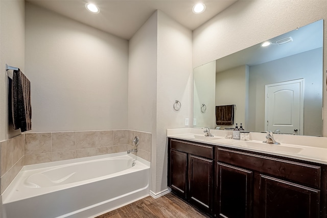 18623 Swainboro Dr, New Caney, TX 77357 - full bathroom featuring wood finished floors, double vanity, a garden tub, and recessed lighting