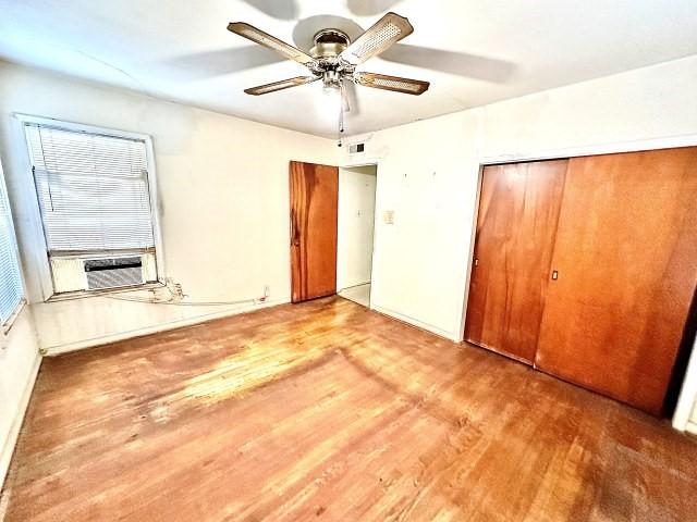 515 Vaky St, Corpus Christi, TX 78404 - unfurnished bedroom with wood finished floors, a closet, cooling unit, and a ceiling fan