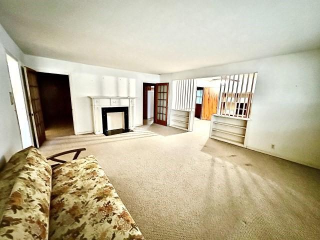 515 Vaky St, Corpus Christi, TX 78404 - unfurnished living room with carpet flooring and a fireplace with flush hearth