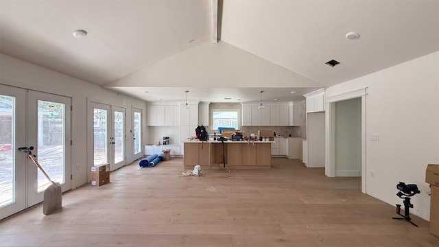 10047 Meadow Lake Ln, Houston, TX 77042 - kitchen with french doors, white cabinetry, beamed ceiling, light wood finished floors, and plenty of natural light