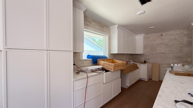 10047 Meadow Lake Ln, Houston, TX 77042 - kitchen with white cabinets, tile walls, decorative backsplash, light countertops, and wood finished floors